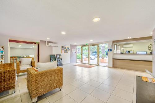 - un salon avec des fauteuils en osier et un canapé dans l'établissement Résidence Pierre & Vacances Les Platanes, à Sainte-Maxime