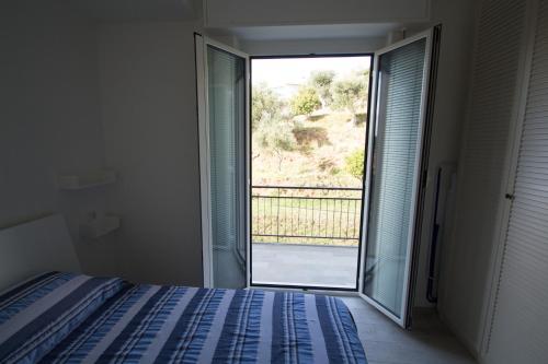 a bedroom with a bed and a large window at appartamento super ristrutturato in Celle Ligure