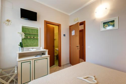 シローロにあるDaniela Camereのベッド1台と壁掛けテレビが備わる客室です。