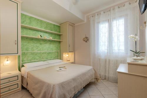 Habitación pequeña con cama y ventana en Daniela Camere, en Sirolo