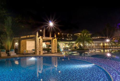 a swimming pool in front of a building at night at Movenpick Resort & Spa Boracay in Boracay