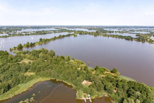 an aerial view of a river with trees and water at The Outpost Lakehouse- enjoy our house at Reeuwijkse Plassen - near Gouda in Reeuwijk