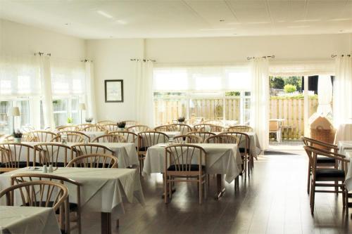 een eetkamer met tafels en stoelen met witte tafellakens bij Hotel Lisboa in Frederikshavn