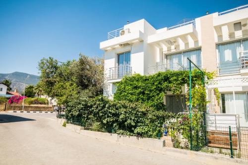 a white house with a fence and bushes at Amazing Two-Bedroom Apartment in Residence Lukomorye D5 with scenic view in Karavas