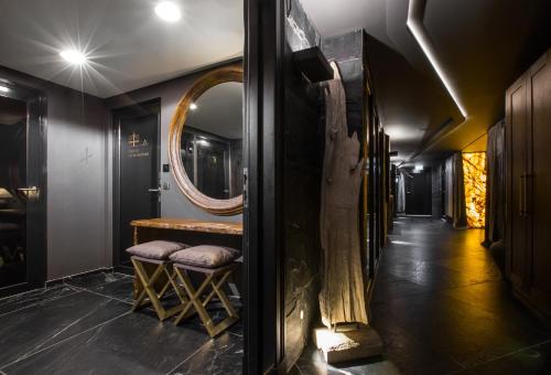 a hallway with a mirror and a table and stool at Hotel Pacai, Vilnius, a Member of Design Hotels in Vilnius