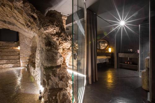 a bathroom with a glass shower in a stone wall at Hotel Pacai, Vilnius, a Member of Design Hotels in Vilnius