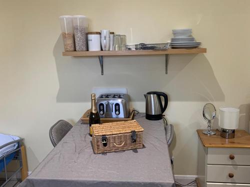 a table with a bottle of wine and a toaster at Southernwood - Wantage Road Studio 1 in Didcot
