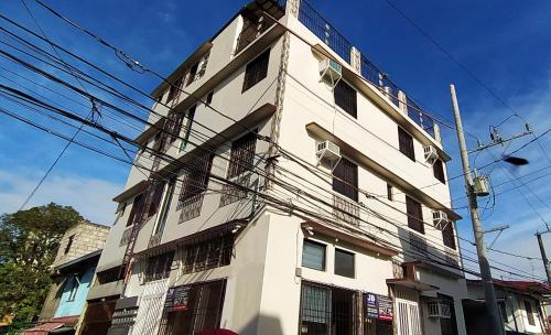 a tall white building with lots of windows at JB Valdres Apartment in Manila