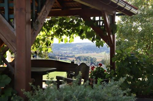 a wooden pergola with a bench in a garden at Sonntagsberg Hof Familie Fiedler in Bad Waltersdorf