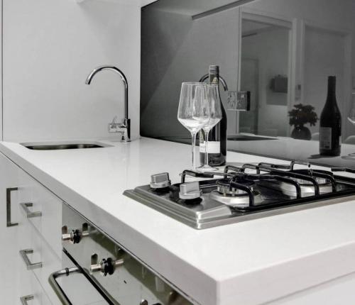 a kitchen with a stove and a wine glass on a counter at ReadySet Apartments on Little Collins in Melbourne