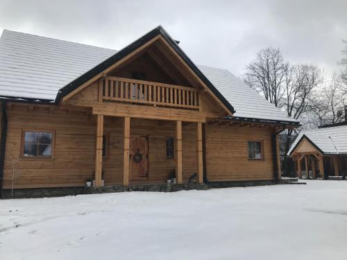 a log cabin with snow on the ground at Fajna Chatka in Ustrzyki Dolne