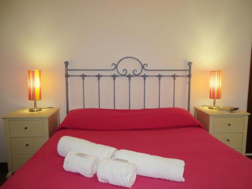 ein Schlafzimmer mit einem roten Bett mit zwei Lampen in der Unterkunft CASA DA BARRA AZUL by Stay in Alentejo in Vila Nova de Milfontes