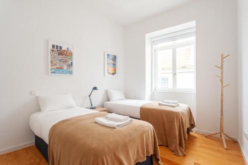 里斯本的住宿－FLH Chiado Amazing Flat，白色墙壁客房的两张床