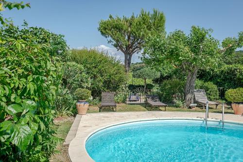 奧朗日的住宿－Chambres d'Hôtes et Gîtes Le Mas Mellou，庭院内的游泳池,配有两把椅子和树木
