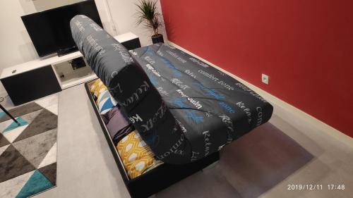 a couch sitting in the corner of a room at 15 min walk to DisneylandParis, 5 min walk to Val d'Europe Mall and train RER A, Monyhome apartment for 4 persons in Chessy