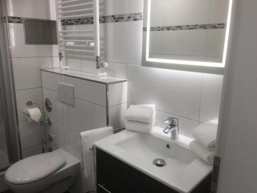 a white bathroom with a sink and a toilet at Inselresidenz Strandburg Apartment 209 in Juist