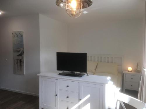 a living room with a tv on a white dresser at Inselresidenz Strandburg Apartment 209 in Juist
