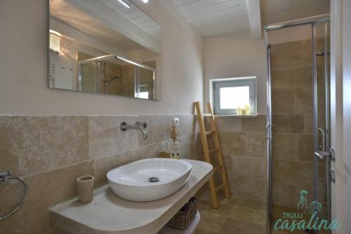 a bathroom with a sink and a shower at Trulli Casalina in Cisternino