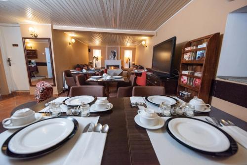 a dining room with a table with white dishes on it at Archontiko Argyro in Makrinítsa