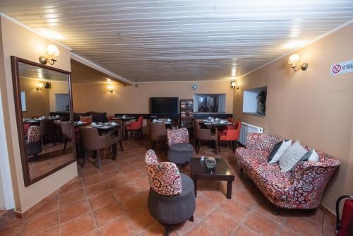 a restaurant with couches and tables and a dining room at Archontiko Argyro in Makrinítsa