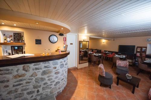 a bar in a restaurant with a stone wall at Archontiko Argyro in Makrinítsa