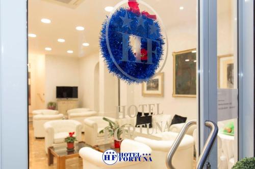 a waiting room with white chairs and a blue wreath at Hotel Fortuna in San Bartolomeo al Mare