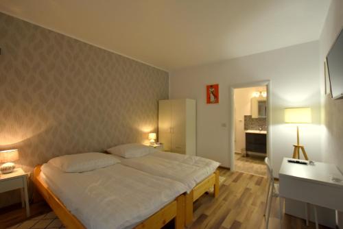 a bedroom with a large bed and a desk and a desk at Neferprod Apartments - IS - CAM 02 in Timişoara