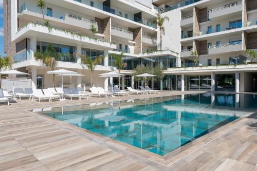 a swimming pool in front of a building at YOUMAMI Suite Hotel Wellness&Spa in Giulianova