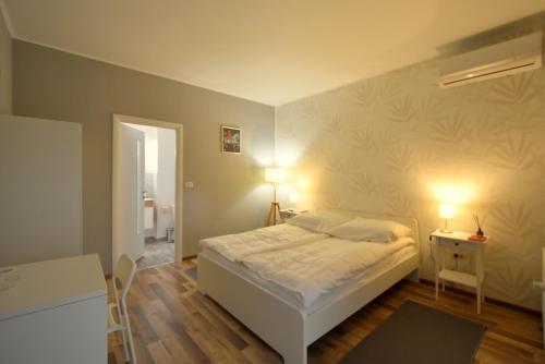 sypialnia z łóżkiem, stołem i 2 lampami w obiekcie Neferprod Apartments - IS - CAM 04 w mieście Timişoara