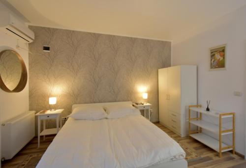 um quarto com uma cama branca e duas mesas de cabeceira em Neferprod Apartments - IS - CAM 03 em Timisoara