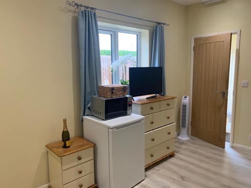 a room with a dresser with a television on top of it at Southernwood - Wantage Road Studio 2 in Didcot