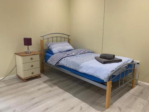 a bedroom with a bed and a dresser with a lamp at Southernwood - Wantage Road Studio 2 in Didcot