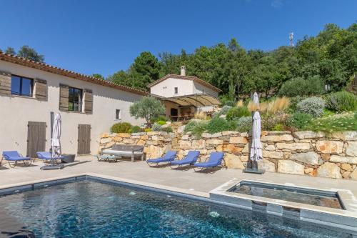 une maison avec piscine à côté d'un mur de pierre dans l'établissement Villa Suzanne, à La Garde-Freinet
