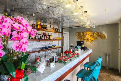 a bar with pink flowers on the counter in a room at Helen Fin Inn & Apartment in Phnom Penh