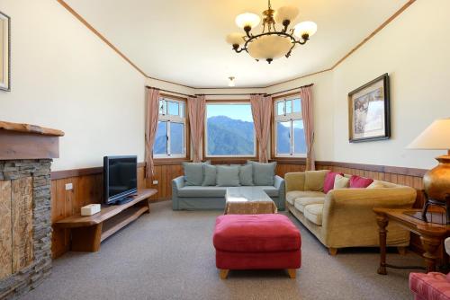 a living room with a couch and a tv at Aurora Villa in Renai