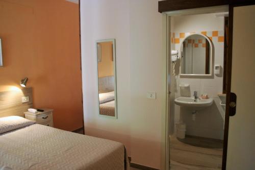 a hotel room with a bed and a mirror at Hotel Maristella in Cavo