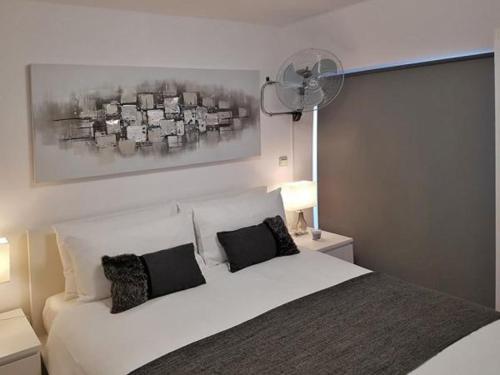 a bedroom with a white bed with black pillows at SP Luxury Loft 28 in Ravda
