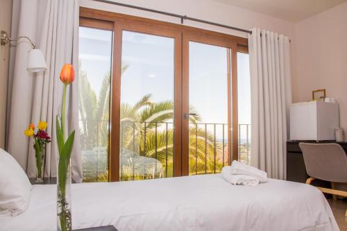 Hotel Gran Sol في كاليبي: غرفة نوم بسرير ابيض ونافذة كبيرة