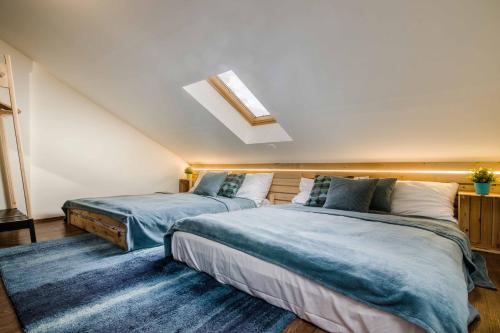 a bedroom with two beds and a skylight at APT with sunny garden Prague by Michal&Friends in Prague