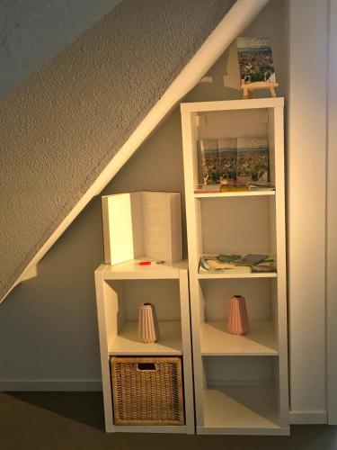 ein Bücherregal unter der Treppe mit einer Kiste in der Unterkunft Studio Emilie in Detmold