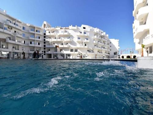 a view of a building from the water in front of a building at Apartment Sorrento near the sea RedSeaLine in Hurghada