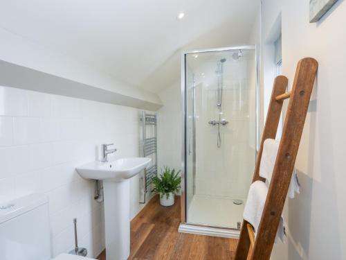 a bathroom with a sink and a shower at Burton Apartment in Trearddur