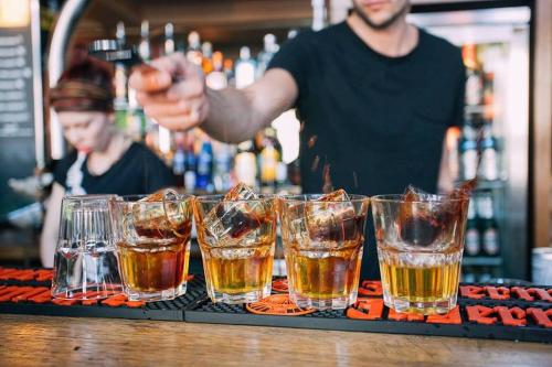 un barman préparant un bar avec plusieurs verres de bière dans l'établissement St Christopher's Inn Budget Hotel Paris - Gare du Nord, à Paris