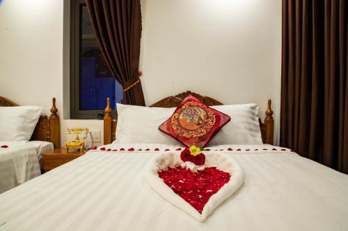 a white bed with a heart made out of roses at Money Fine Quy Nhơn - Khách sạn dát vàng in Quy Nhon