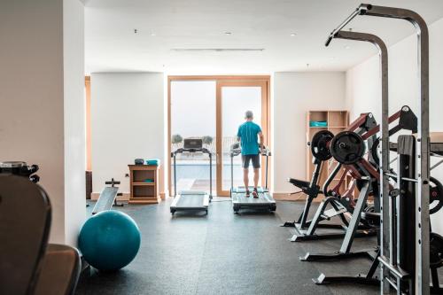 a man standing in a gym looking out the window at Mitsis Selection Blue Domes in Kardamaina