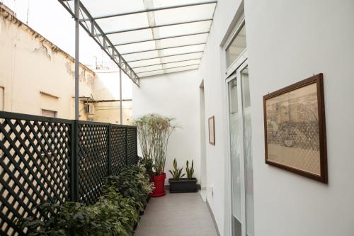 a corridor of a building with plants and a picture on the wall at Ninarella Napoli in Naples