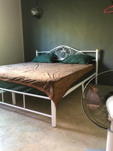 a bed with a metal frame and green pillows at BP Room 2 budget in Ko Mak
