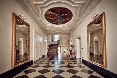 a hallway with two mirrors and a ceiling at Hotel Schloss Freudental in Allensbach