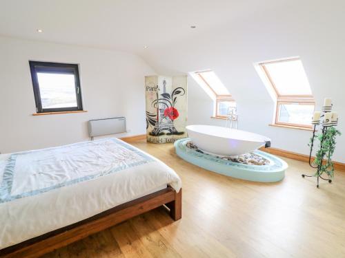 1 dormitorio con 1 cama grande y bañera grande en Ocean Sail House, en Dungloe