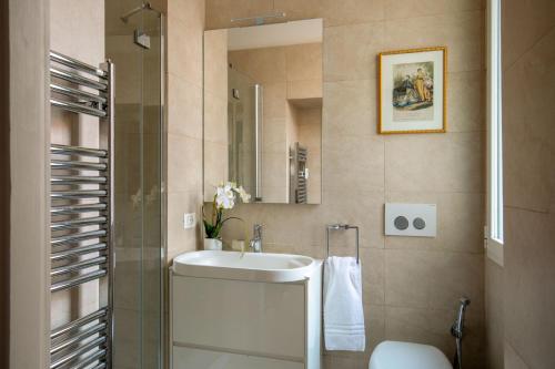 un baño con lavabo y espejo en Avignonesi Suites - CA Domus Collection, en Roma